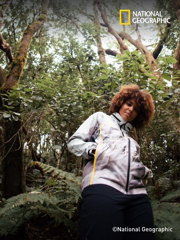 A woman in nature wearing the adidas TERREX x © National Geographic collab jacket and pants.