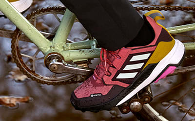 A close-up on shoes cycling through a puddle.