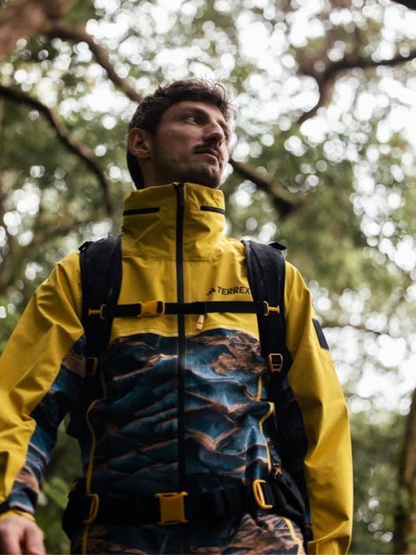 A man in nature wearing the adidas TERREX x © National Geographic collab jacket.