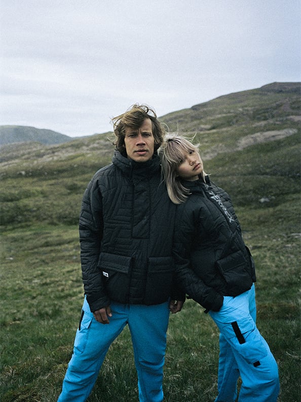 female and male model wearing the mtbr anorak posing in front of highland scenery