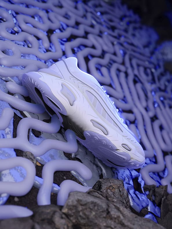 Futuristic blue and grey space background. A front-view of a chunky, white futuristic trainer with adidas three-stripe design placed in the middle of the image.