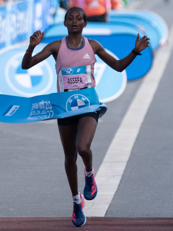 Montage featuring close-ups of Adizero Pro 3 worn by runners in motion, and GIF of Tigist Assefa crossing finish line at Berlin Marathon 2022