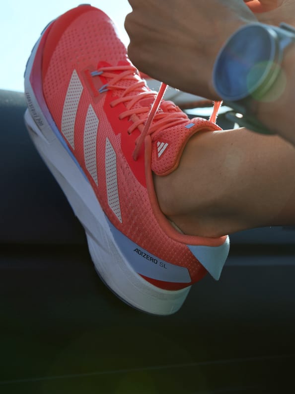 "[SL] A detailed image of the Adizero SL being laced up against a railing."
