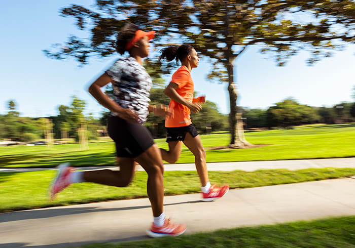 Image of 2 runners, one men and women, running together in the park.