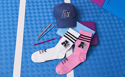 Socks, pencils and a hat laying on the ground.