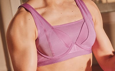 image of model's chest wearing a pink medium support sports bra