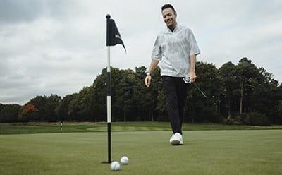 Man in golf pants in golf practice area