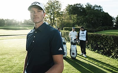 Man on golf course in navy blue shirt