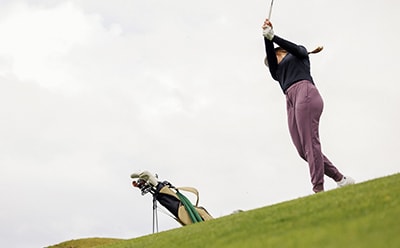 Female golfer with purple pants 