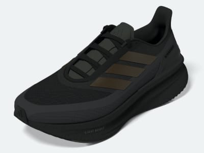 A black and gray athletic shoe with a thick sole and laces sits on a plain white background.