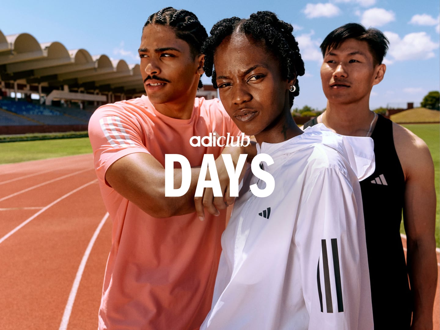 Three people stood together on a red running track striking a strong pose towards the camera.  