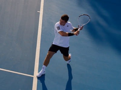 A man player wearing the adidas tennis collection on the court.