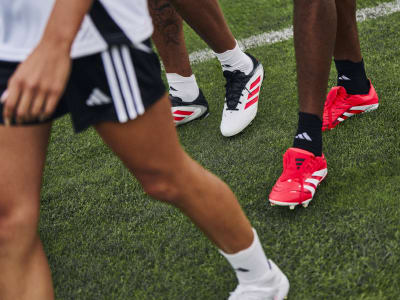 Footballers wearing adidas football boots on the pitch
