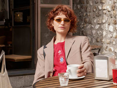 Woman having coffee while wearing FC Bayern Munich lifestyle jersey