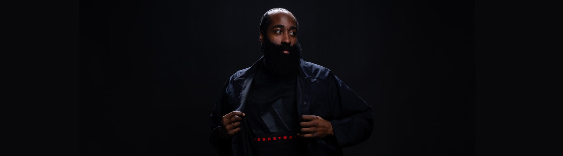 Close-up of James Harden facing camera in dark environment