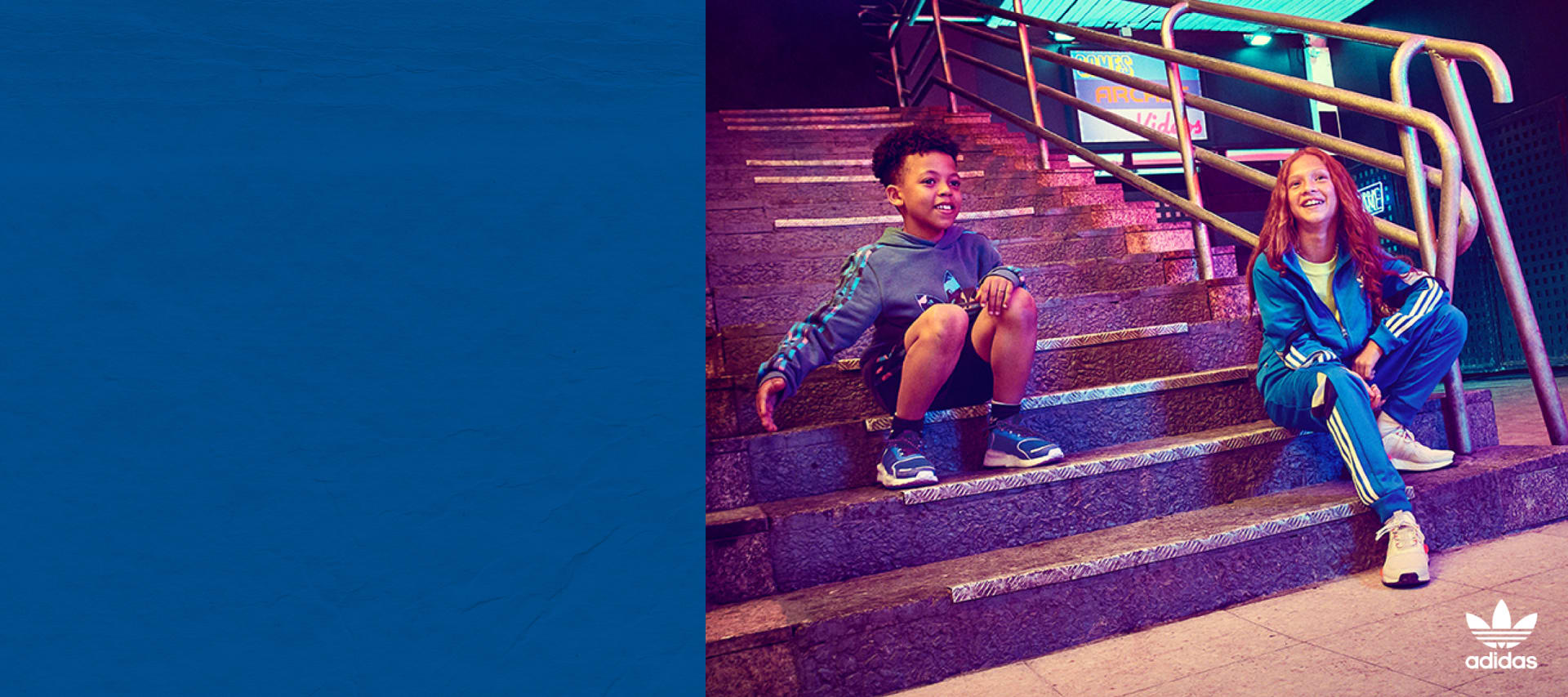 Two kids playfully pose in the latest evolution of the NMD.