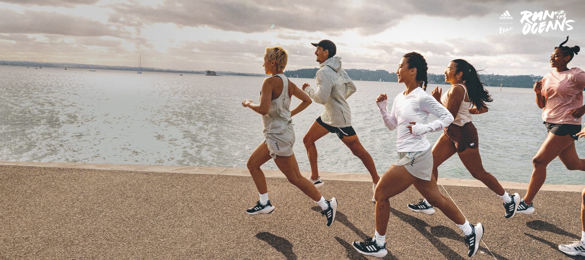 Group of men and women running by the ocean