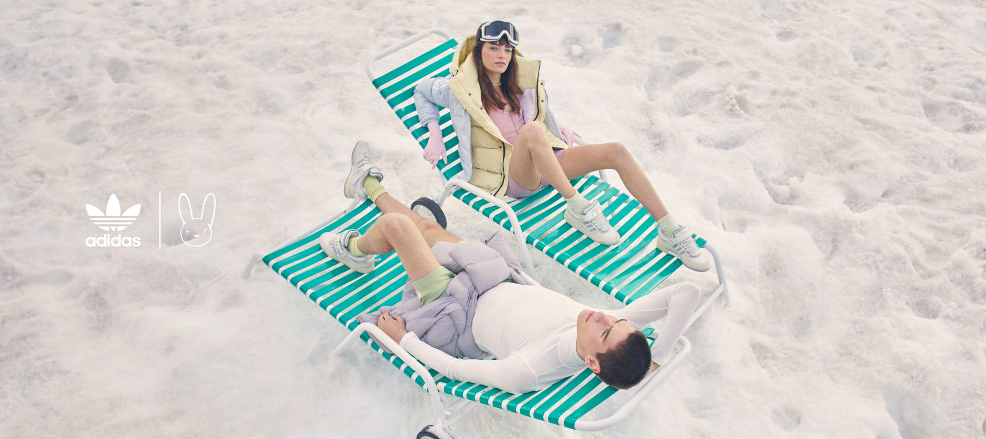 Two models laying on deck chairs in the snow, wearing the Bad Bunny White Forums.