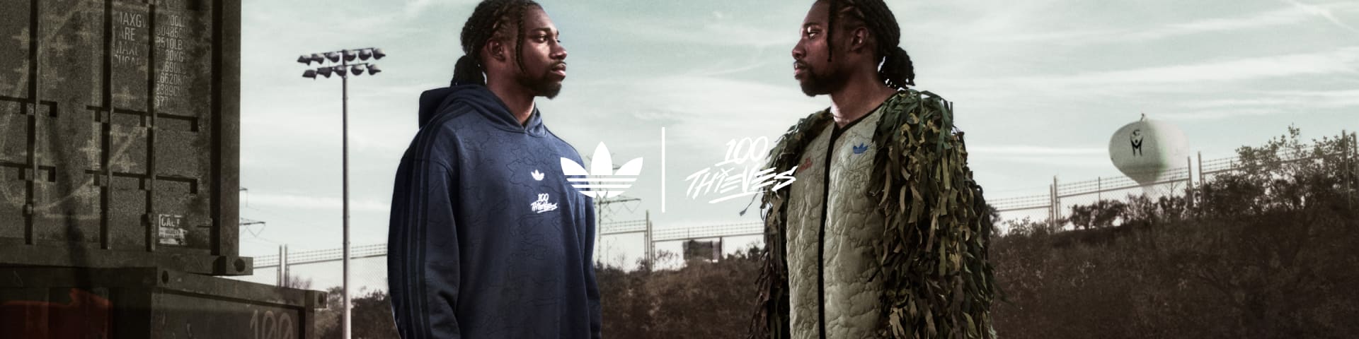 Noah Lyles stands face-to-face with his double, both wearing the full adidas Originals x 100 Thieves collection.