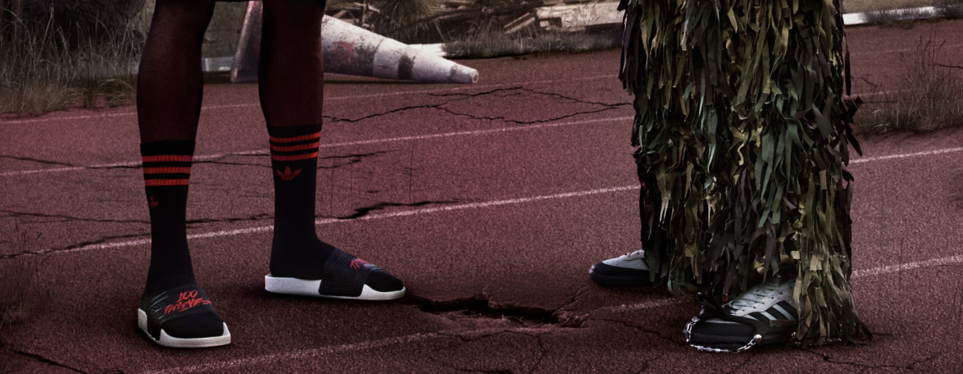 Two people shown from the waist down—one in adidas shorts, socks, and sneakers; the other in military camouflage pants and sneakers.