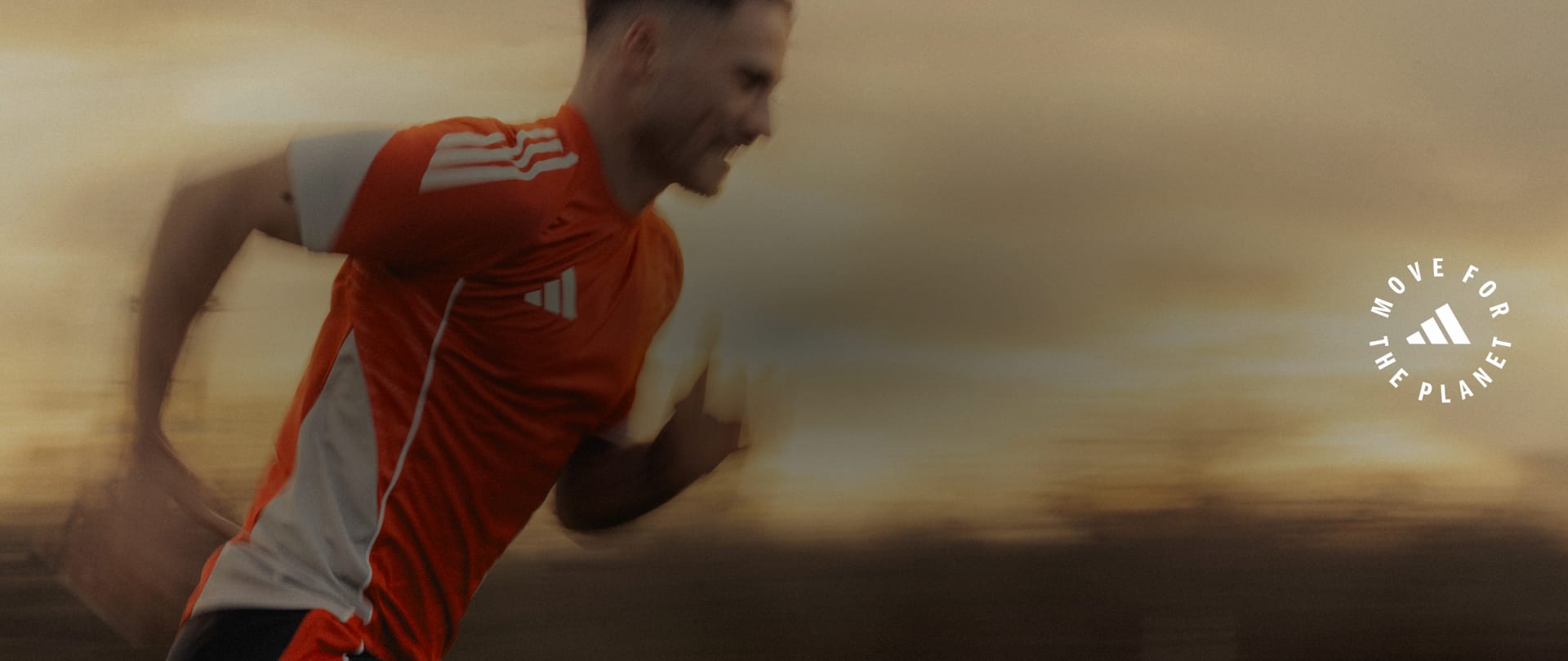 A person wearing a red and white athletic jersey stands in a blurred, hazy background with a dramatic sky.