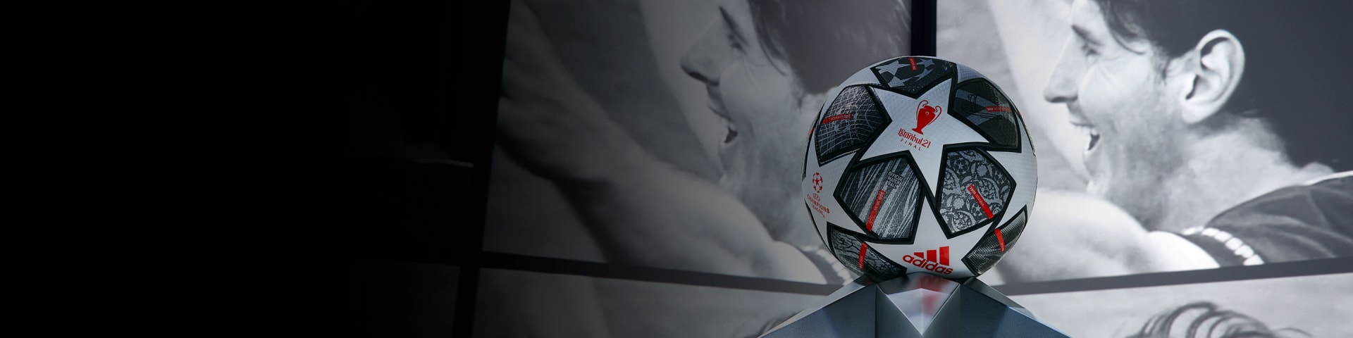 ball on plinth surrounded by screens featuring messi