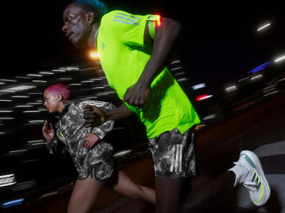 Two people running at night in adizero