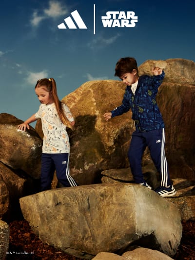 Two children playing on boulders wearing the adidas | Young Jedi collection