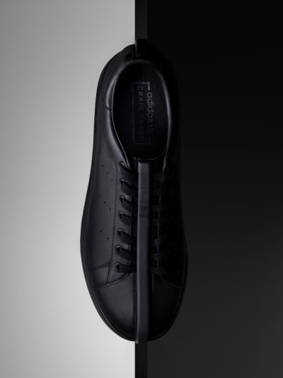 The CG Split Stan sneaker is pictured vertically in front of a half light, half dark backdrop.