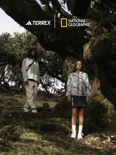Female and male model wearing the Terrex National Geographic collection posing in rain forest scenery