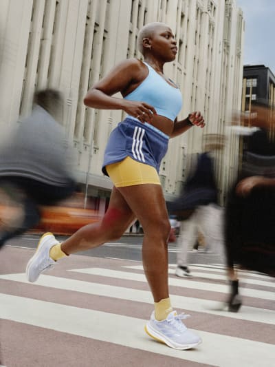 Woman running outdoors wearing adidas Supernovas.