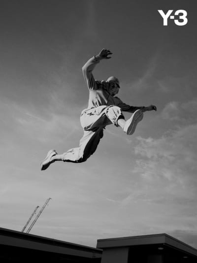 A freerunner performs an athletic leap wearing Y-3.
