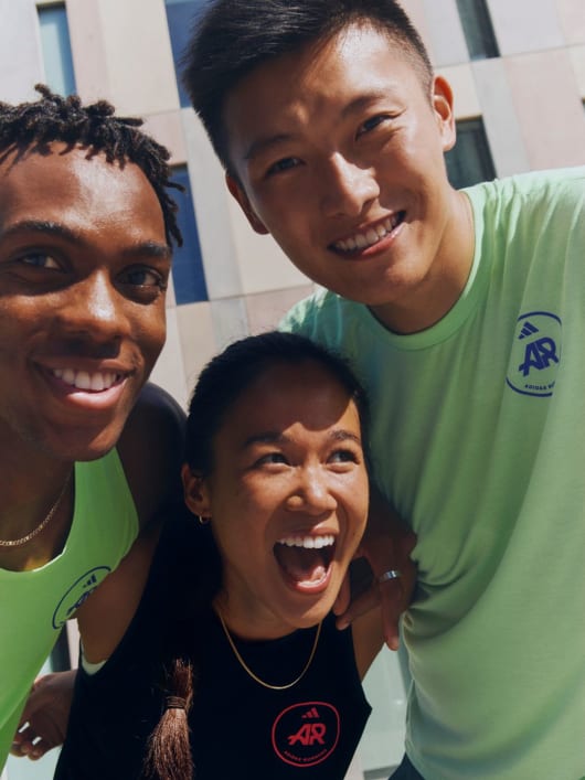 An image of three adidas Runners members with their arms around each other, smiling. 