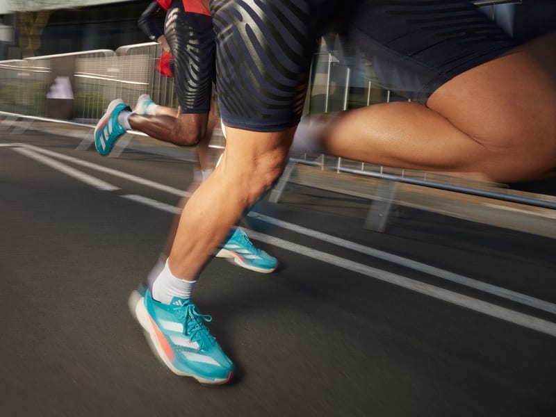 Close up of athletes legs wearing Adizero running shoes.