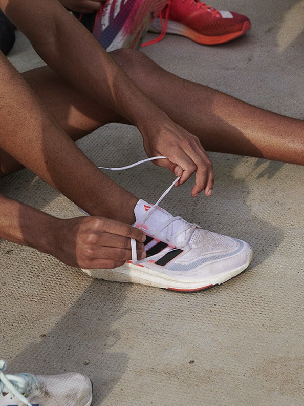 Woman tying Ultraboost Light running shoes.