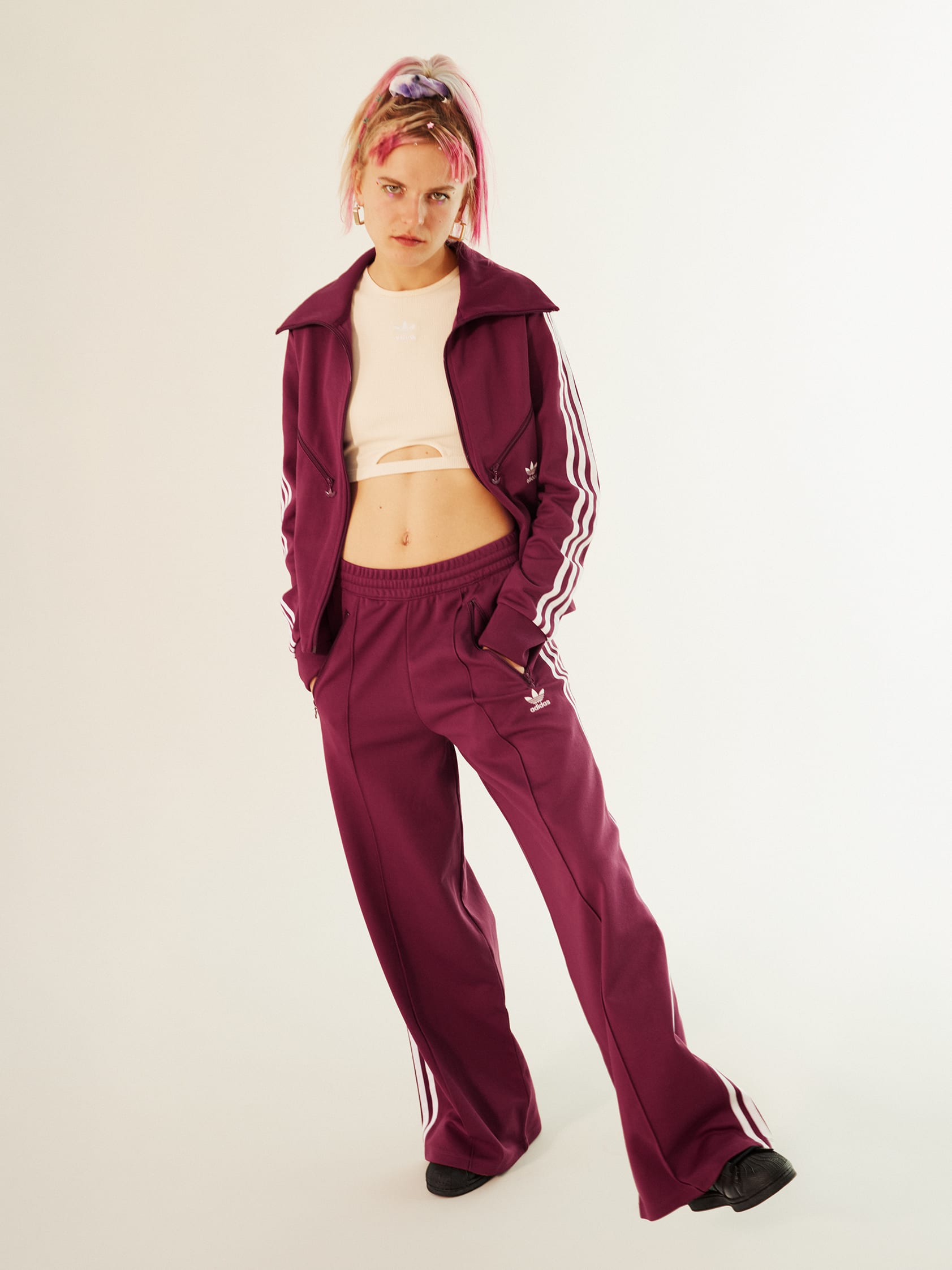 Stylish woman wearing a classic dark red adicolor tracksuit.