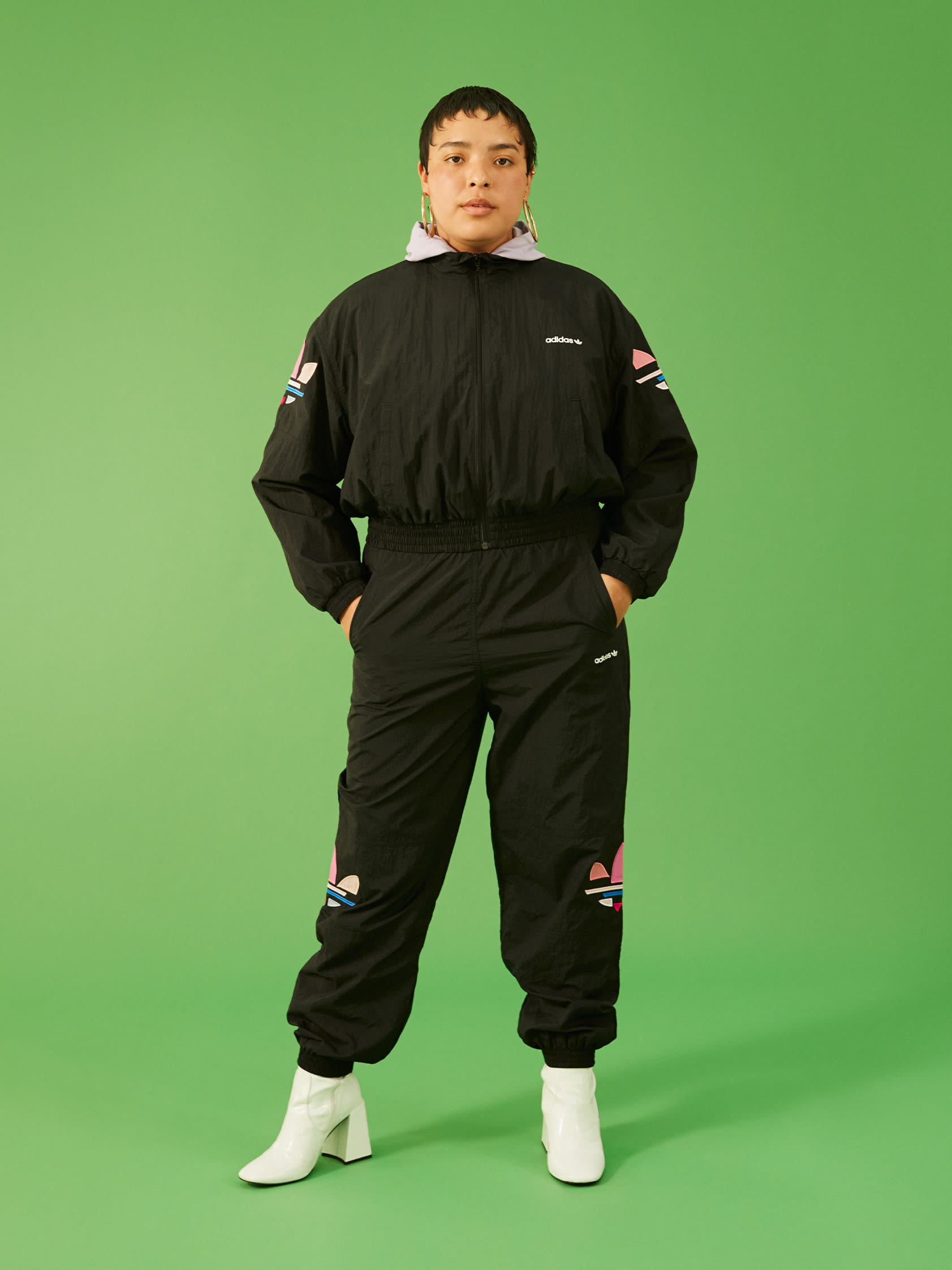 Expressive woman poses in bold black adicolor outift.