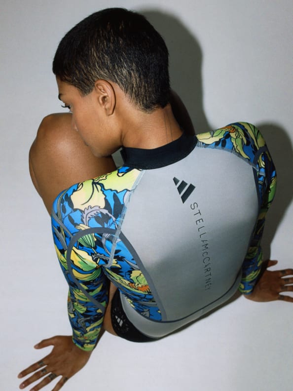 Thara is sitting down wearing the Truenature Swimsuit from the new SS23 adidas by Stella McCartney.