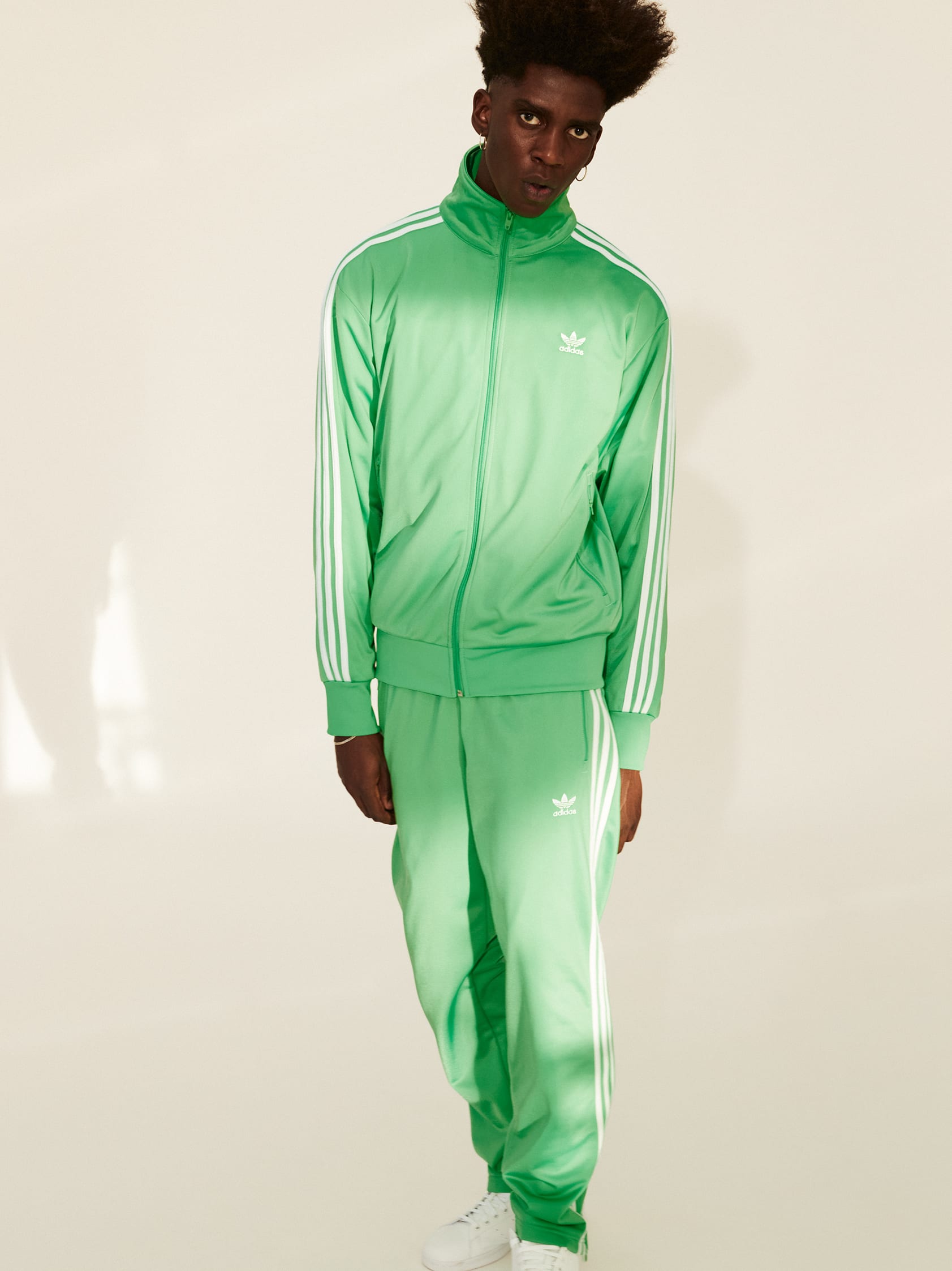 Stylish men and a woman pose in classic, bold and contemporary adicolor outfits.