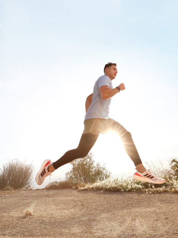 Image of man running outdoors wearing Ultraboost Light shoes.