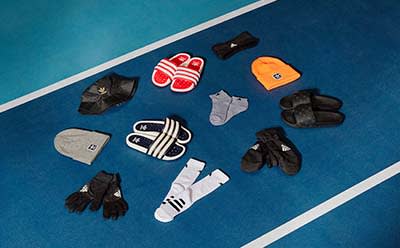 Collection of cold-weather accessories (hats, gloves, socks) displayed together on sports gym floor.