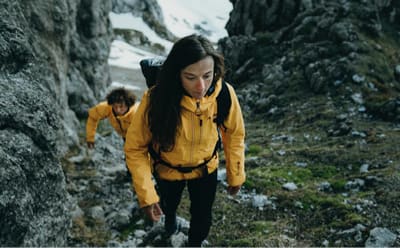 A woman and a men are enduring a climb while hiking wearing TERREX matching jackets.