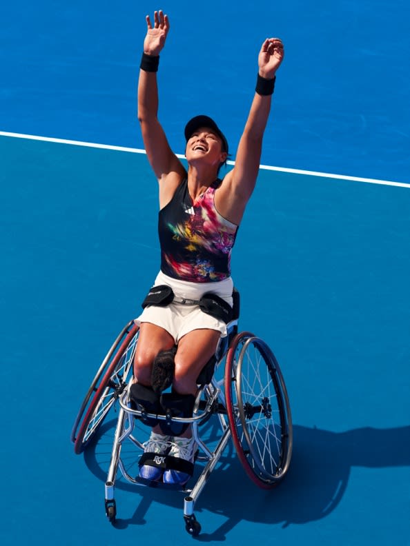 Person in wheelchair holding their arms up in victory