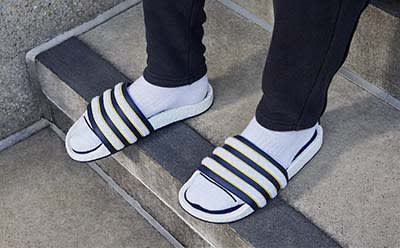 Close up of model wearing pairs of socks and slides.