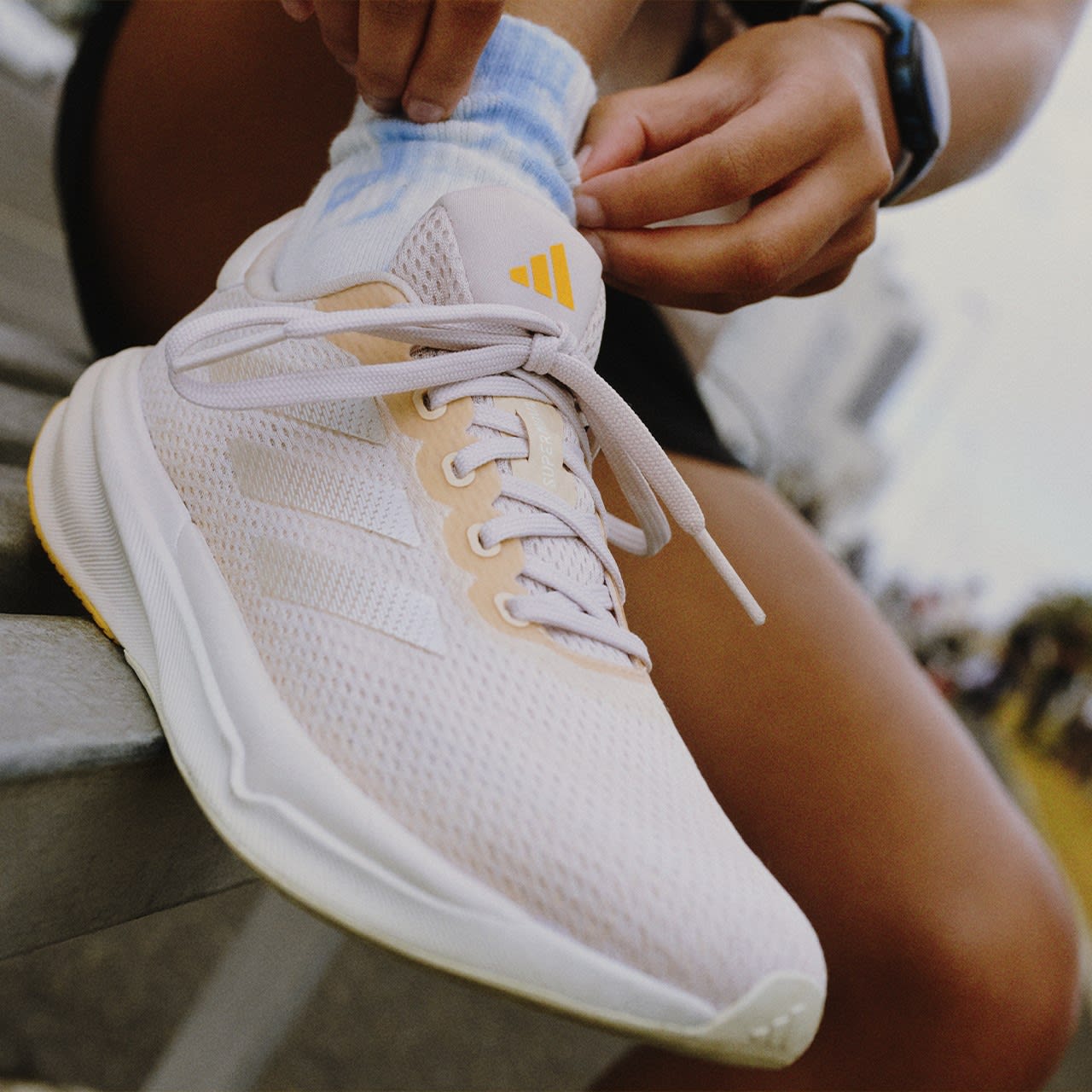 Close-up image of a woman lacing up her Supernovas.