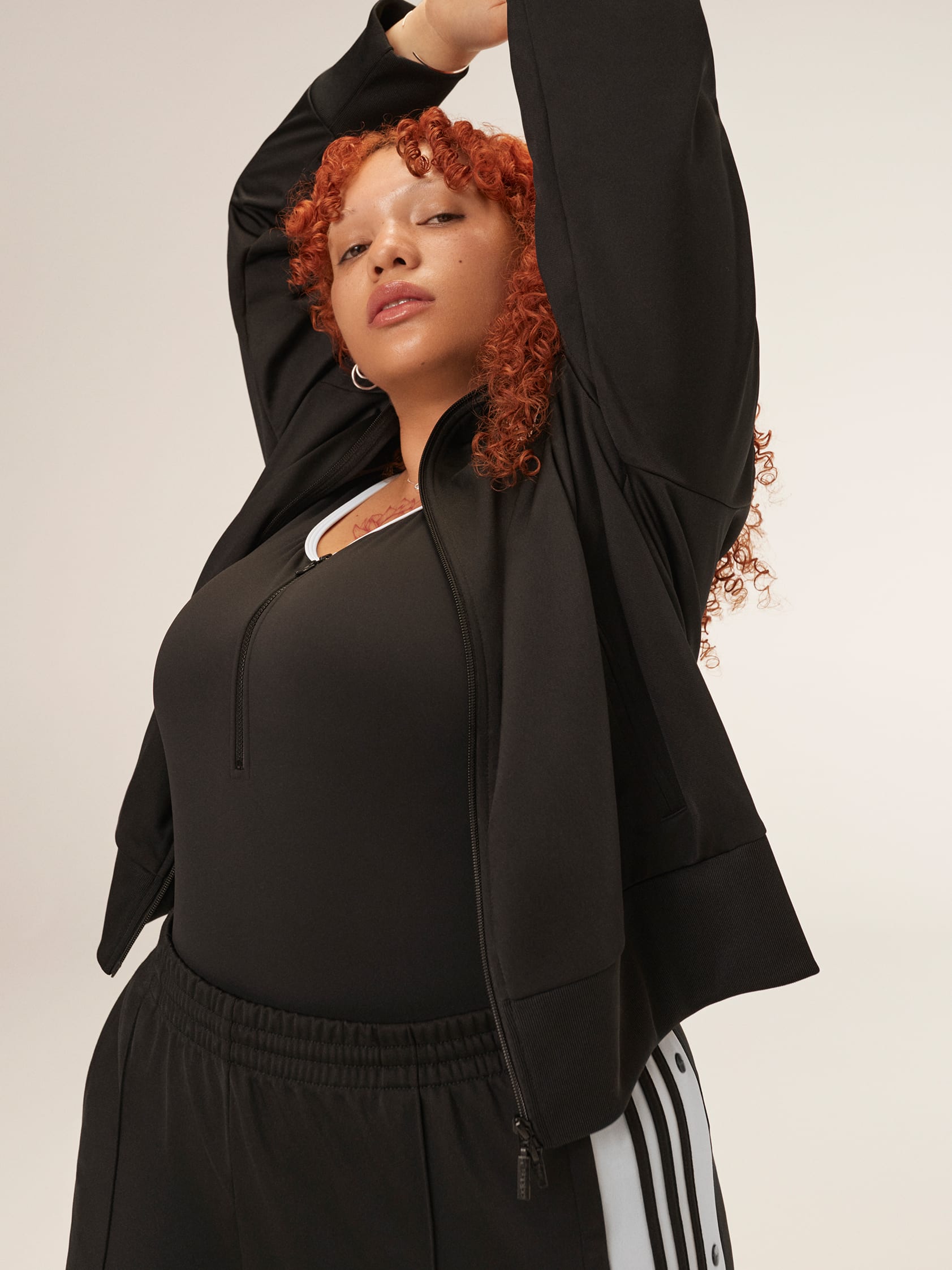 Expressive woman wears classic black adicolor outfit