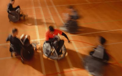 blurry picture of people playing basketball in wheelchairs