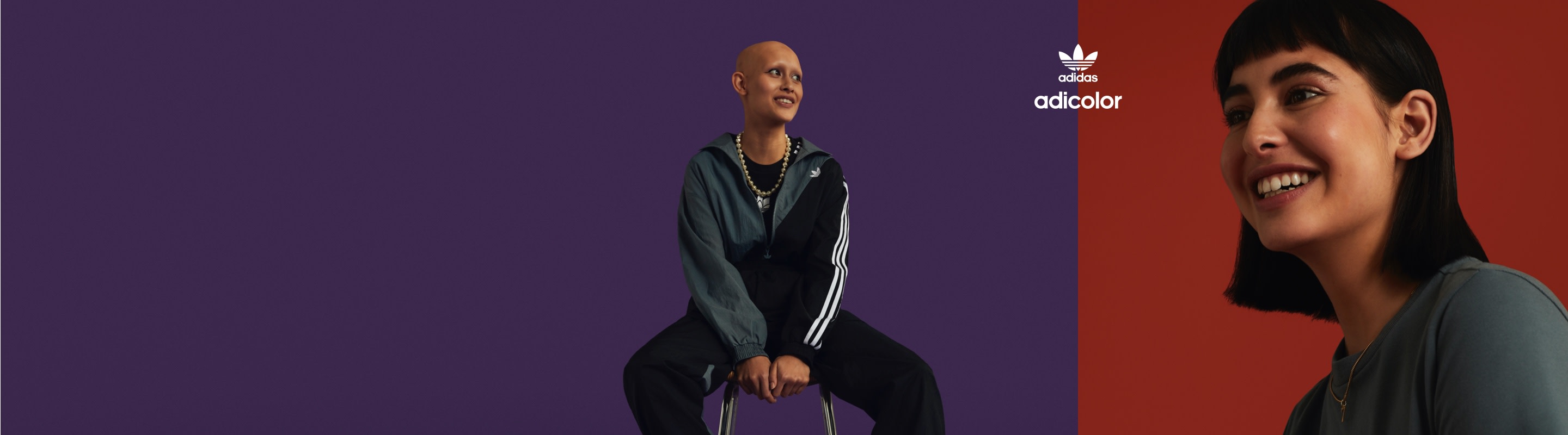 Girl in dark tracksuit sits on chair as girl in grey tee smiles.