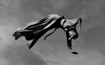 A photograph of a freerunner leaping athletically in front of a building wearing new Y-3 apparel.