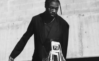 Noah Lyles poses on an LA rooftop in a black-and-white photo, dressed in adidas Y-3 apparel and footwear. 